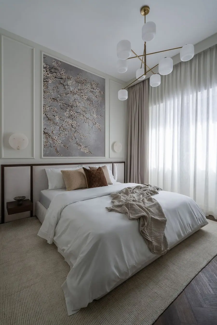 Bedroom with a blossom artwork, wall moulding and a globe chandelier