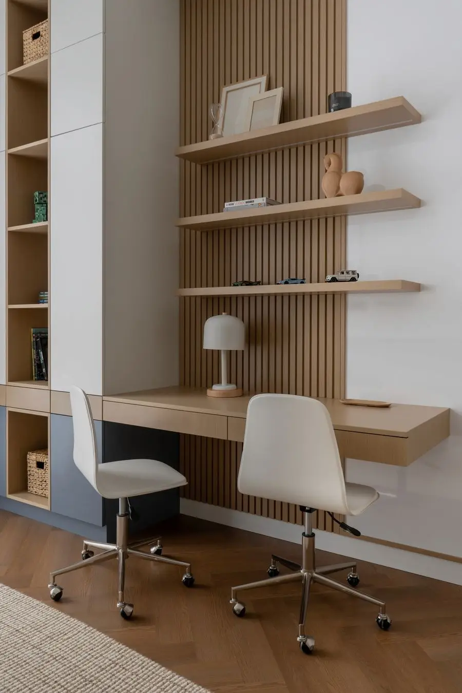 Study corner with oak slat wall shelves, a desk and white chairs