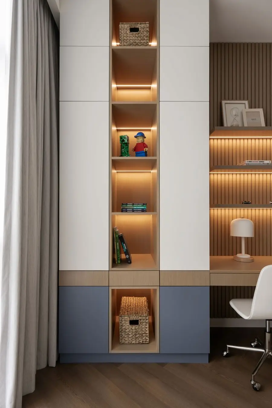 Tall built-in storage with blue lower cabinets and a desk