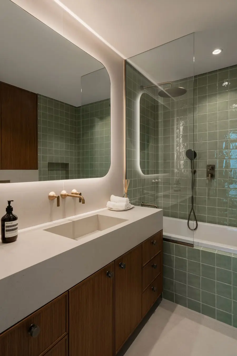 Bathroom with sage tile, an oak vanity and a backlit mirror