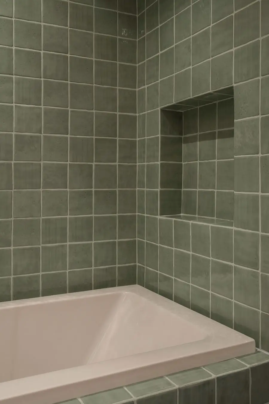 Bathtub in square sage tiles with a recessed niche