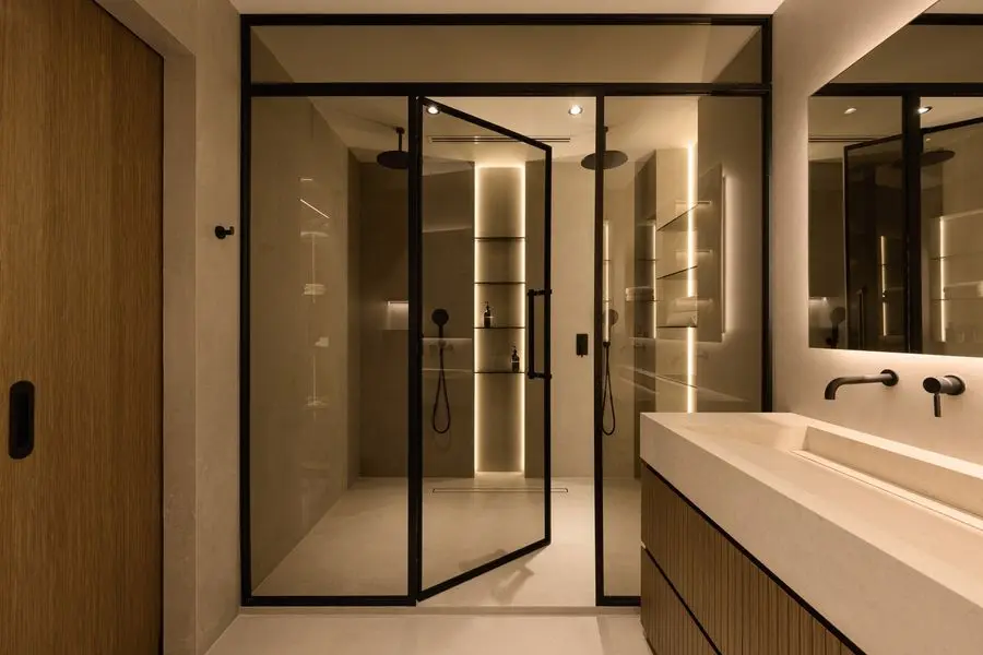 Bathroom with a black-framed walk-in shower and a trough sink