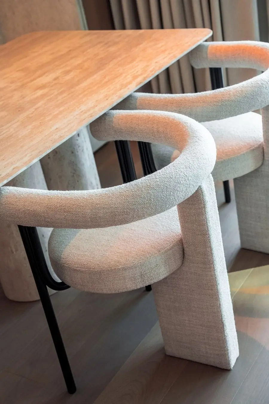 Sculptural bouclé dining chairs at an oak table