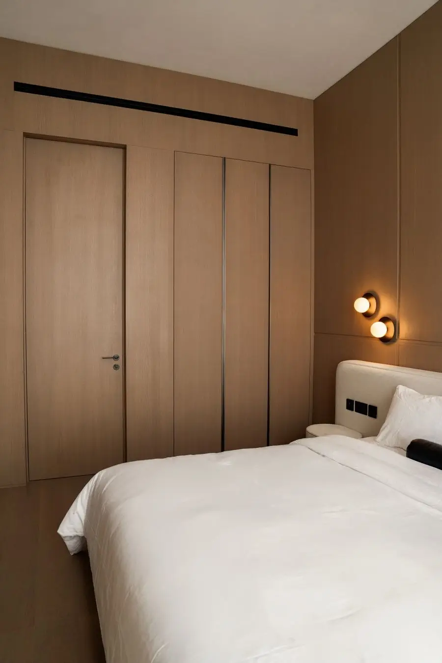 Bedroom with an oak panel wall and a wall sconce