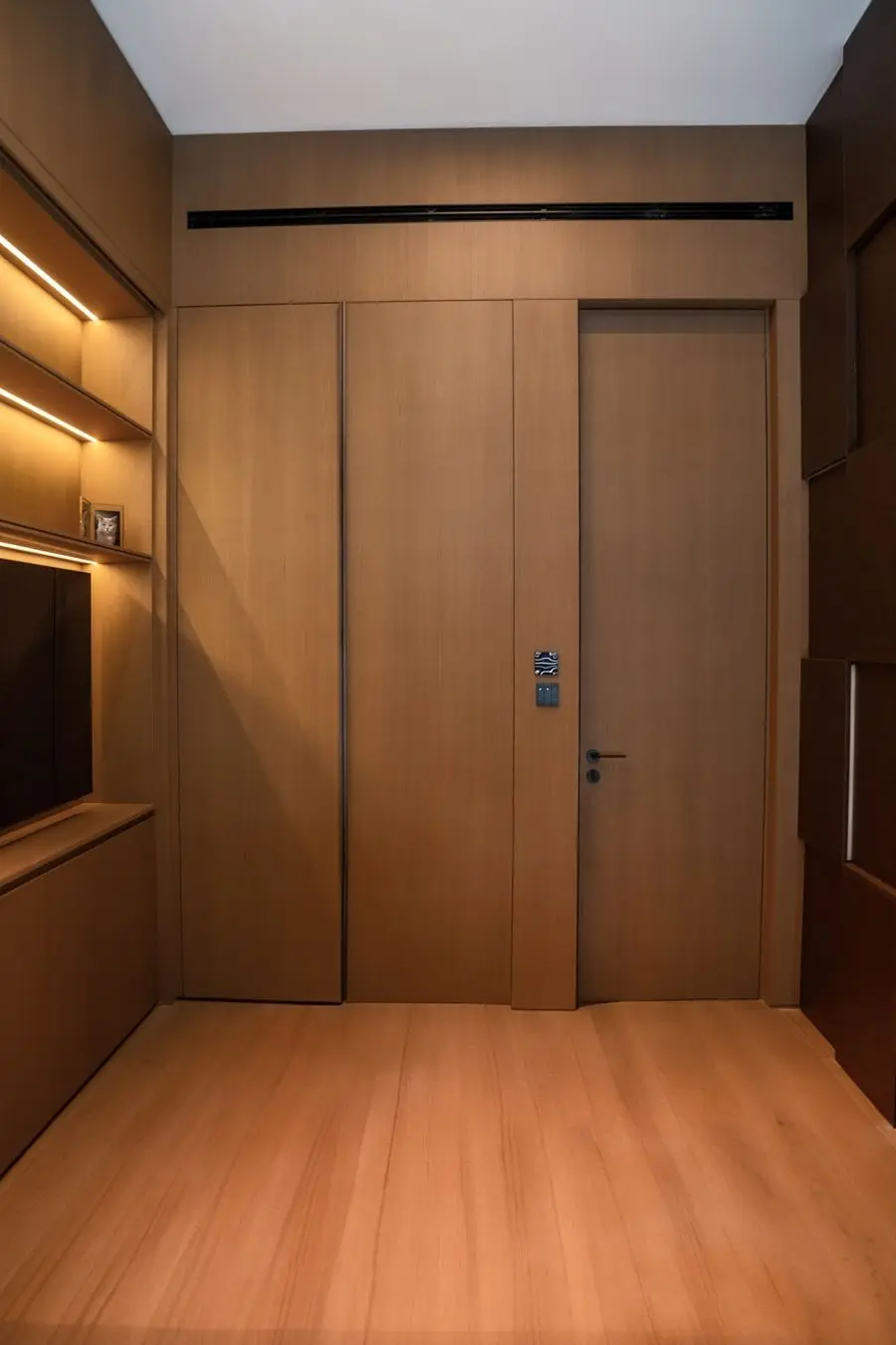 Hallway with concealed oak doors and a backlit shelf