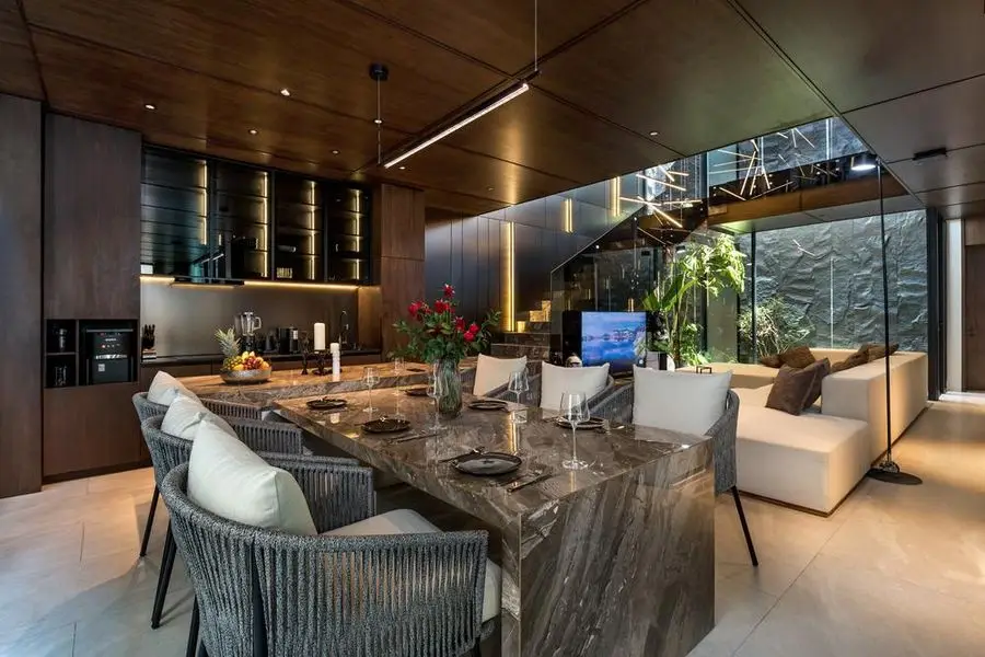 Veined stone dining table with woven chairs in the open living space