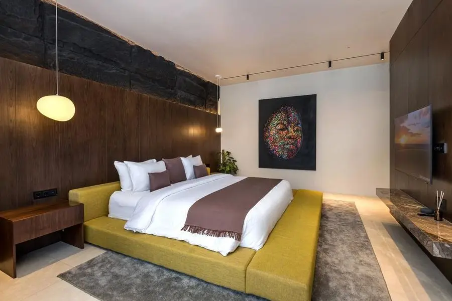 Bedroom with a walnut wall, portrait art and a full-height window