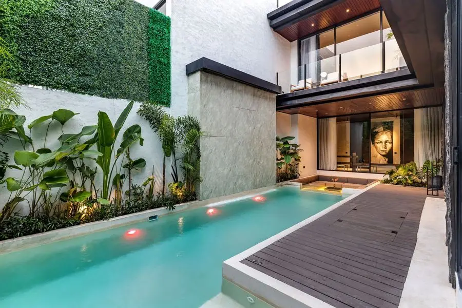 Pool with a timber walkway and a green wall
