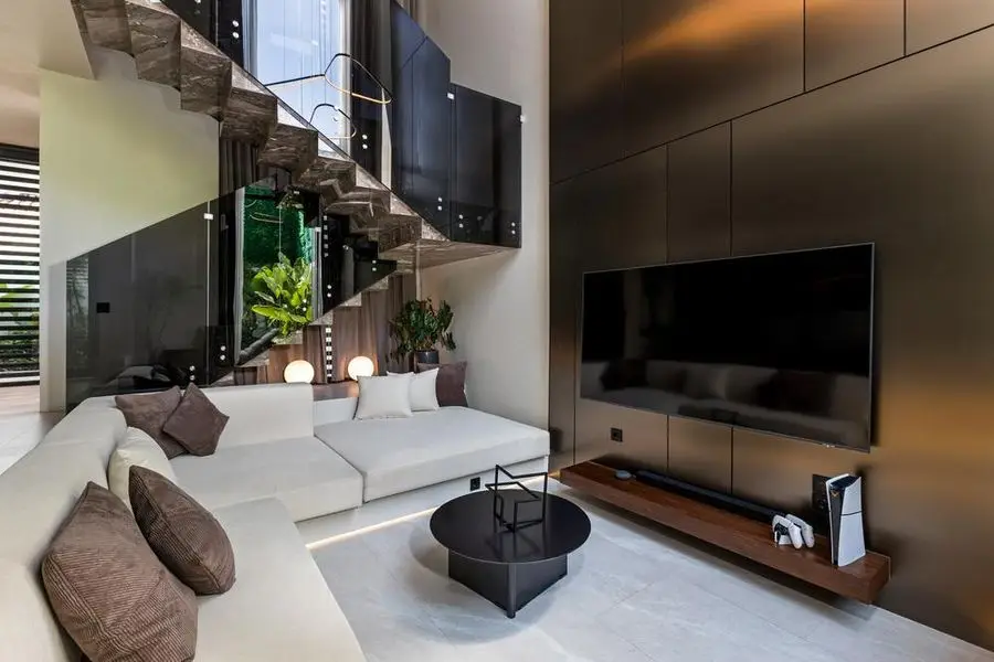 Living room with a walnut media wall and marble stair treads