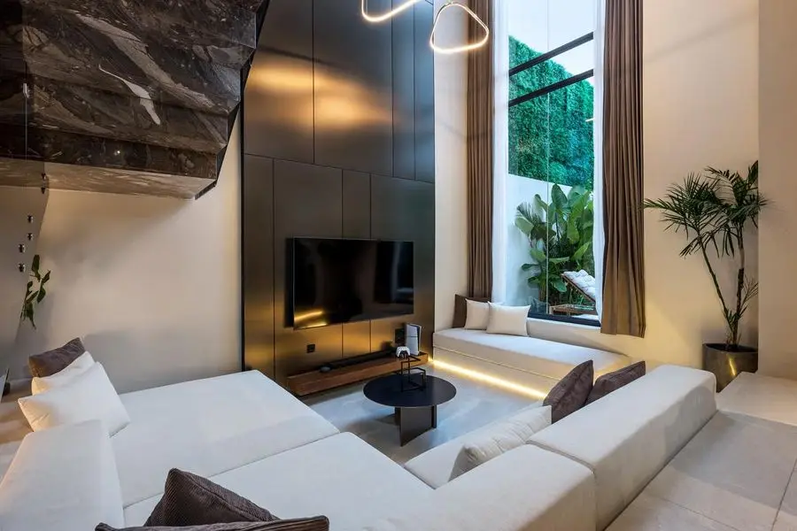 White sectional and marble stair in the double-height lounge
