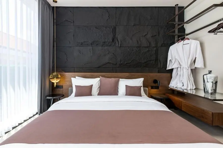 Bedroom with a black textured feature wall and walnut headboard