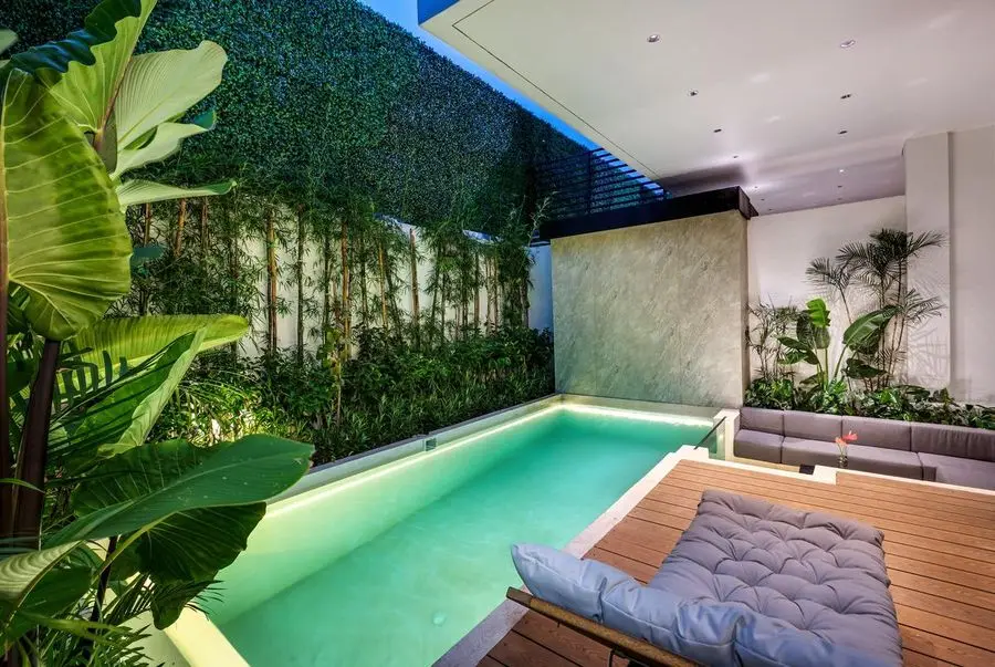 Pool and green wall lit in the evening