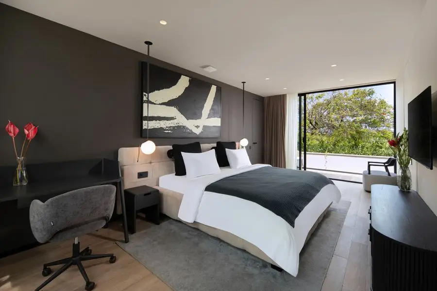 Bedroom with a desk, graphite wall and sliding glass to a terrace