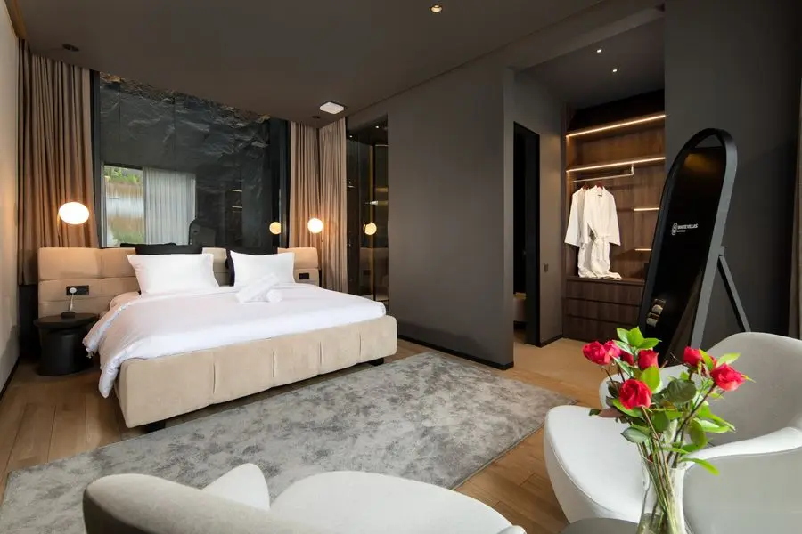 Bedroom with a dark stone feature wall and an open walk-in closet