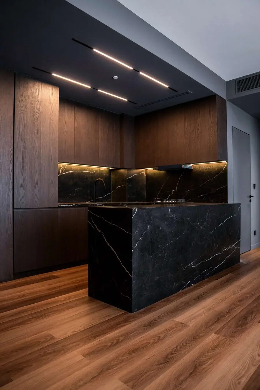 Kitchen with a black stone island and a wood floor