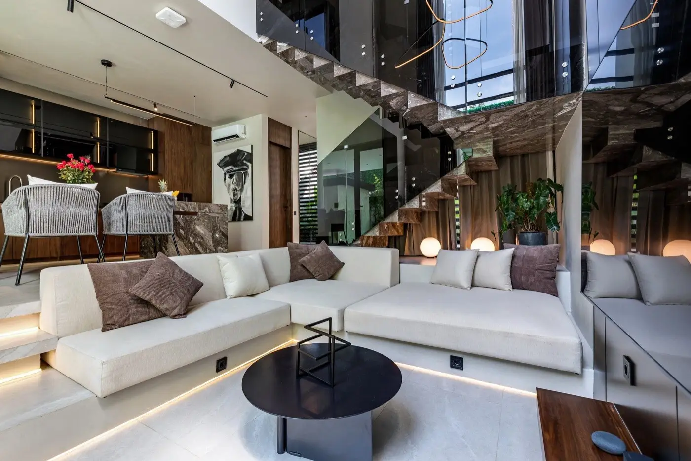 Double-height living room with a white sectional and a grey marble stair