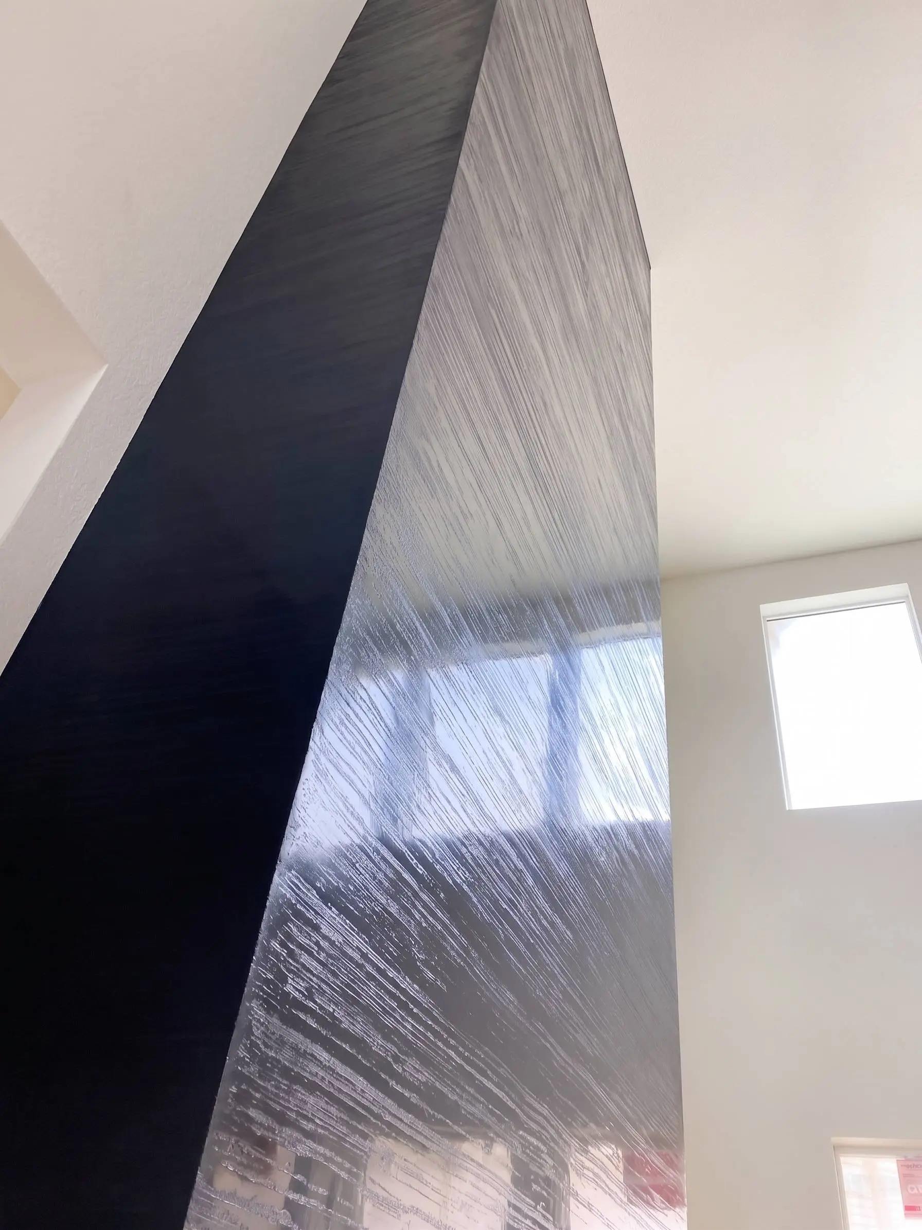 Columna de chimenea en estuco veneciano oscuro con finas líneas de llana, trabajo de nuestros maestros