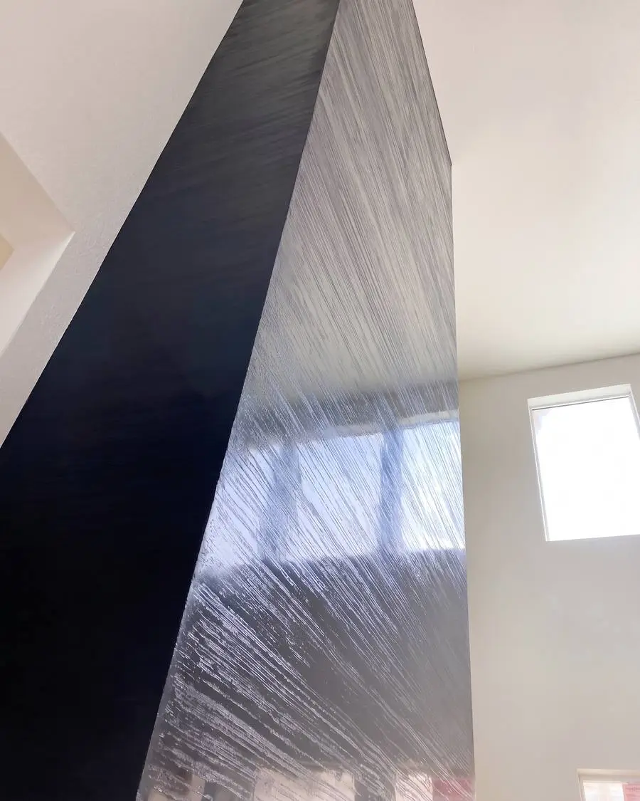 Columna de chimenea en estuco veneciano oscuro con finas líneas de llana