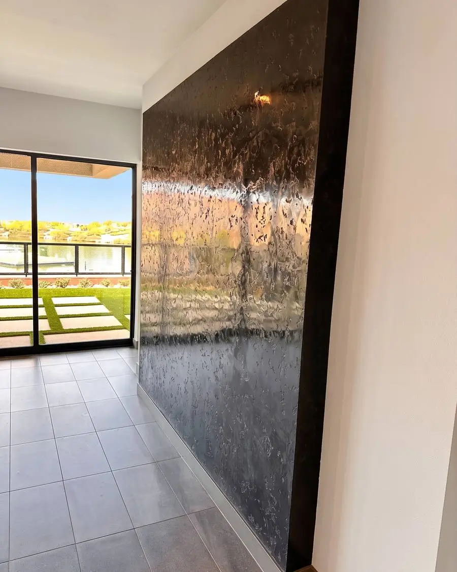 Pared de estuco veneciano pulido de piso a techo junto a una puerta de vidrio